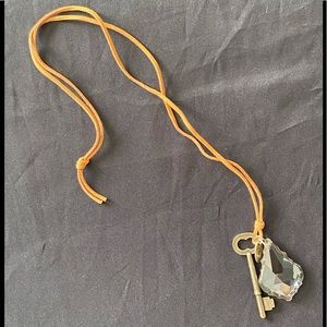 Gold key and distressed crystal on brown cord. 32”